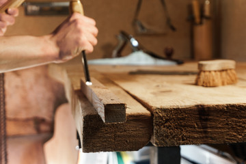 Carpenter carving wood with a chisel