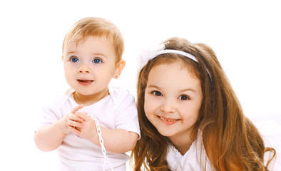 Portrait close-up happy smiling two children, older and younger sister isolated on white background