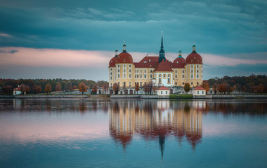 Fototapeta na wymiar Wonderful picturesque Scene with Dramatic Colorful sky. Incredible View of Moritzburg Castle near Dresden, Saxony, Germany reflected in the water, during autumn morning. Instagram filter