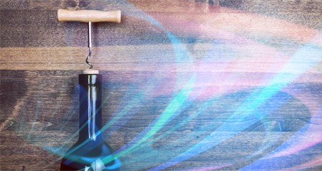 Bottle of wine with corkscrew on wooden background