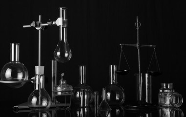 Chemical laboratory variety of flasks and test tubes, chemical scales and burner. Black-and-white photograph