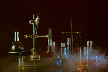 Variety of laboratory vessels with a colored reagents in a rack. A chemical reaction