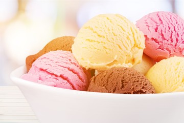 Ice cream scoops in bowl on white background