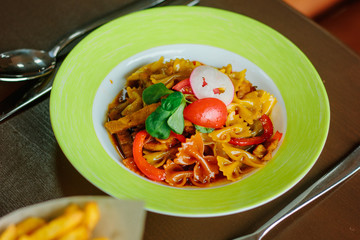 Farfalle pasta in a green plate.