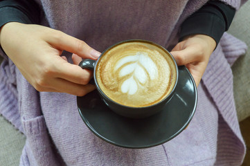 A female hand holding cup of coffee