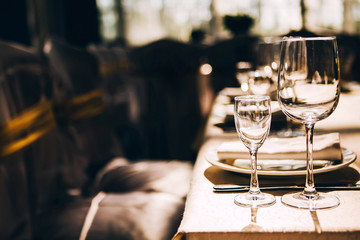 Fototapeta na wymiar Empty wine glasses in sunlight on the banquet table