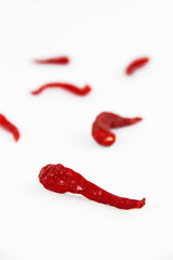 pods of red dried hot bitter edible pepper on a white background