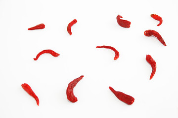 pods of red dried hot bitter edible pepper on a white background