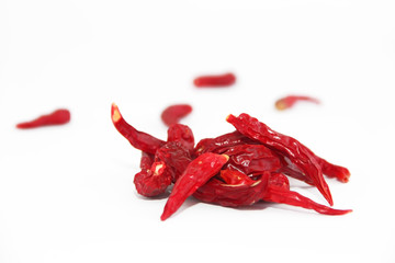 pods of red dried hot bitter edible pepper on a white background