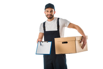 handsome smiling delivery man with cardboard box holding clipboard with blank paper and looking at camera isolated on white