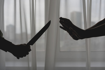 woman put hands forward for protection against a knife in the man's hands