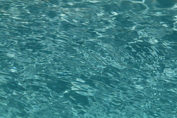 Close up of clean sparkling turquoise swimming pool water, showing good pool maintenance.owing