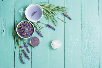cup of lavender tea with a pile of fresh flowers, syrup, sugar candy on blue wood table background