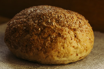 a loaf of rye bread lies on a natural blue textile napkin, the concept of healthy food