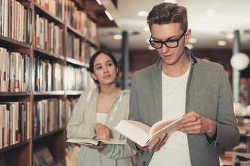 Active handsome man and girl choosing books