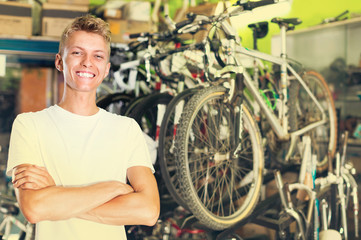 Obraz premium Portrait of male standing near the bicycle in the shop