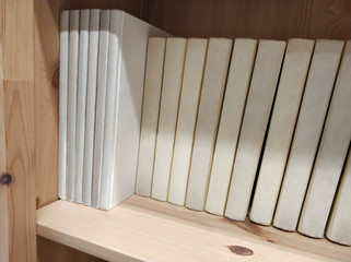 Wooden bookshelf with white books