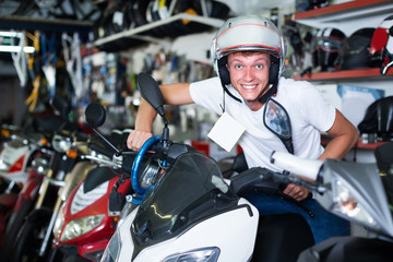 Fototapeta na wymiar Young man in helmet is sitting on motorbike