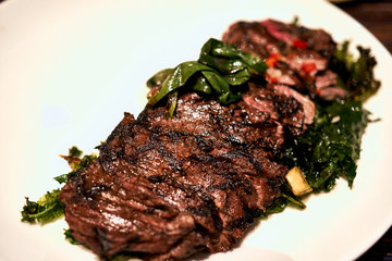 A juicy steak with assorted vegetables on a white plate at a restaurant in Hawaii.
