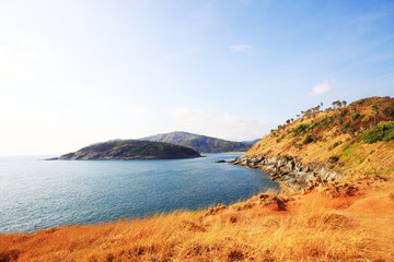 Beautiful seascape with sky twilight of sunset and sea horizon with Calm and blue sky.Dry grass field on mountain of Phrom Thep Cape is famous place in Phuket island, Thailand.