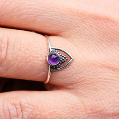 Silver ring with amethyst gemstone caboshon on female hand