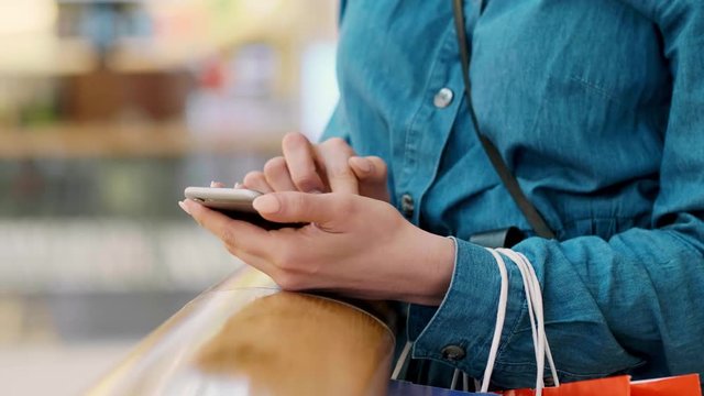 Woman using mobile phone during shopping