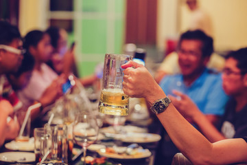Group of unrecognizable people toasting with beer.