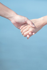 Couple love holding hands on blue sky and sea background. Valentines day and marriage Concept