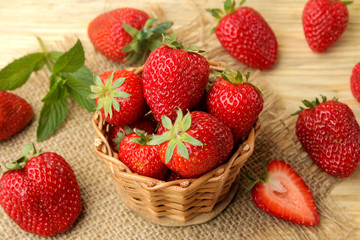 Ripe, delicious strawberries. red berry strawberries in a wicker basket on a natural wooden table
