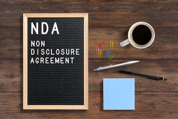 letterboard with acronym NDA for "non disclosure agreement" on wooden background