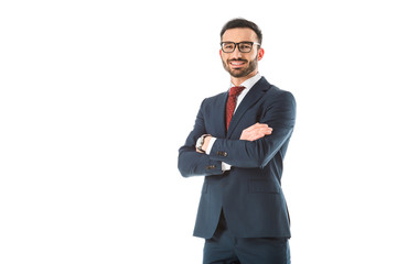 happy businessman standing with crossed arms and looking at camera isolated on white