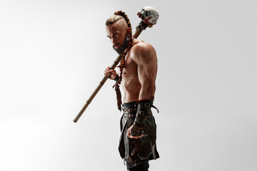 Serious long hair and muscular male model in leather viking's costume with the big mace cosplaying...