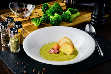 Broccoli cream soup with bread on a table. Classic European food