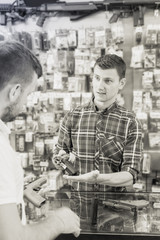 Fototapeta premium Salesman helping customer to choice air gun