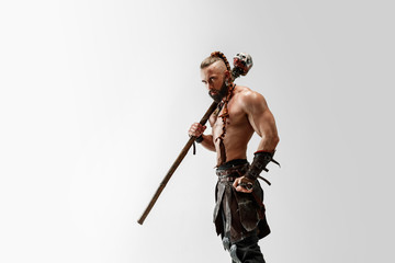 Serious long hair and muscular male model in leather viking's costume with the big mace cosplaying...