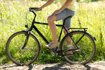 Fototapeta na wymiar people, sport and lifestyle concept - close up of young man riding bicycle outdoors