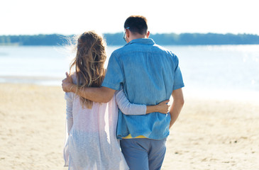 love, summer holidays and people concept - happy couple hugging on beach