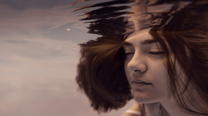 Portrait of a girl in a white dress under water