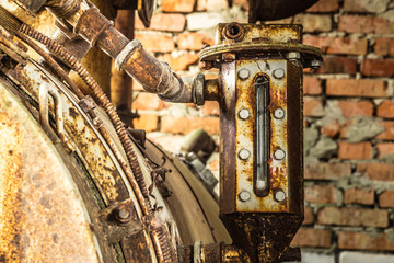 Fototapeta na wymiar Rusted liquid meter of an ancient machine in a abandoned factory