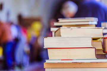 Stack of books at a charity book flea market, text space