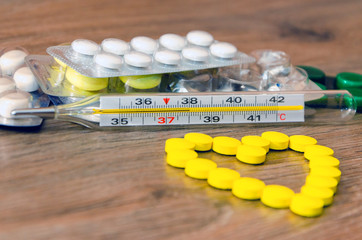 A thermometer with a blister of pharmacy pills