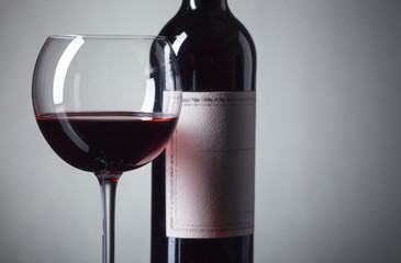 Bottle and glass of red wine .