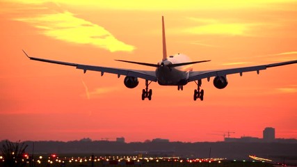 Airplane landing at sunset