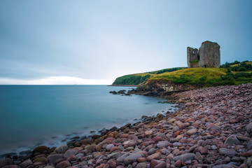 Fototapeta na wymiar Stone beach and the Minard Castle situated on the Dingle Peninsula in Ireland