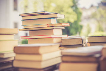 Stack of books at a charity book flea market, text space