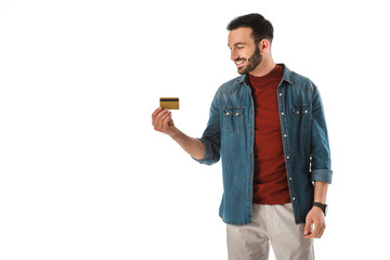 cheerful handsome man in denim shirt holding credit card isolated on white