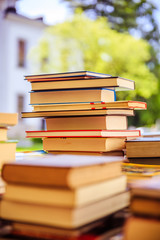 Stack of books at a charity book flea market, text space