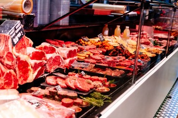 Stand with raw meat in supermarket store.