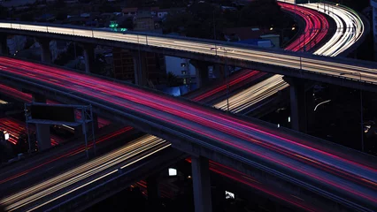 Motion blur of car light in city highway at dawn. Cross intersection of urban highways.