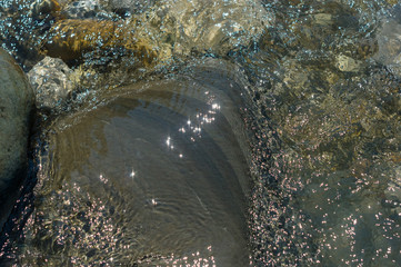 pebble stones on the sea beach, the rolling waves of the sea with foam
